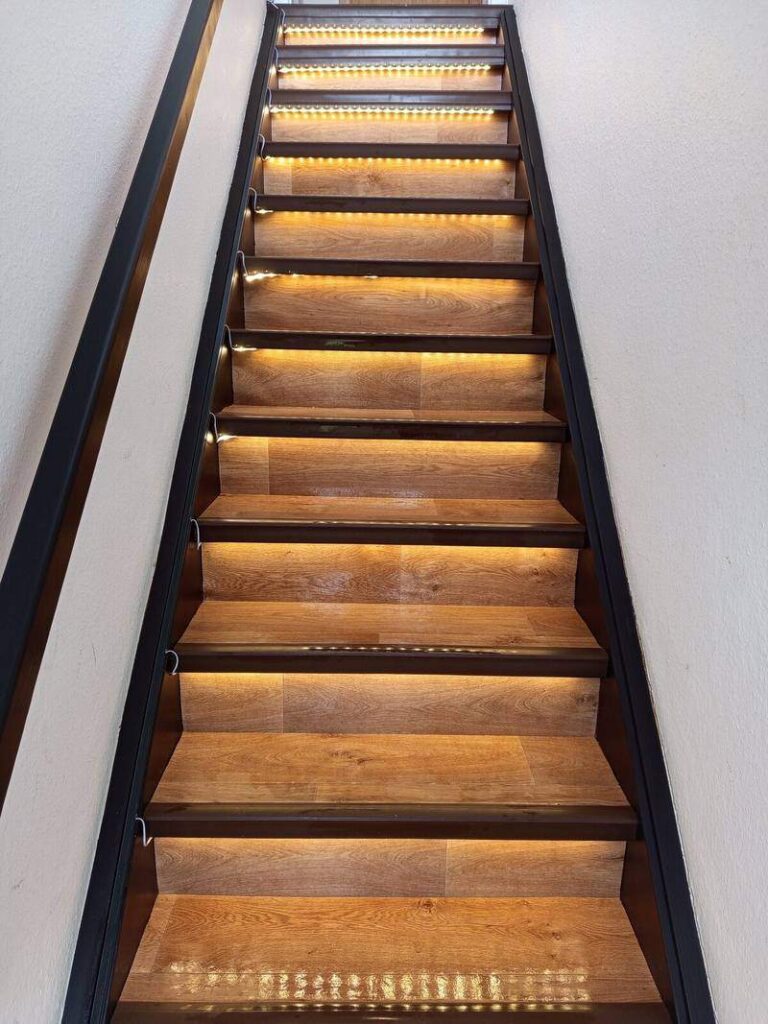 Beleuchtete Holztreppe als eigener Aufgang zur Ferienwohnung