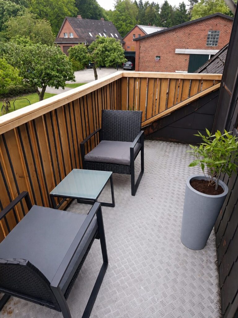 Balkon mit Sesseln und Holzgeländer