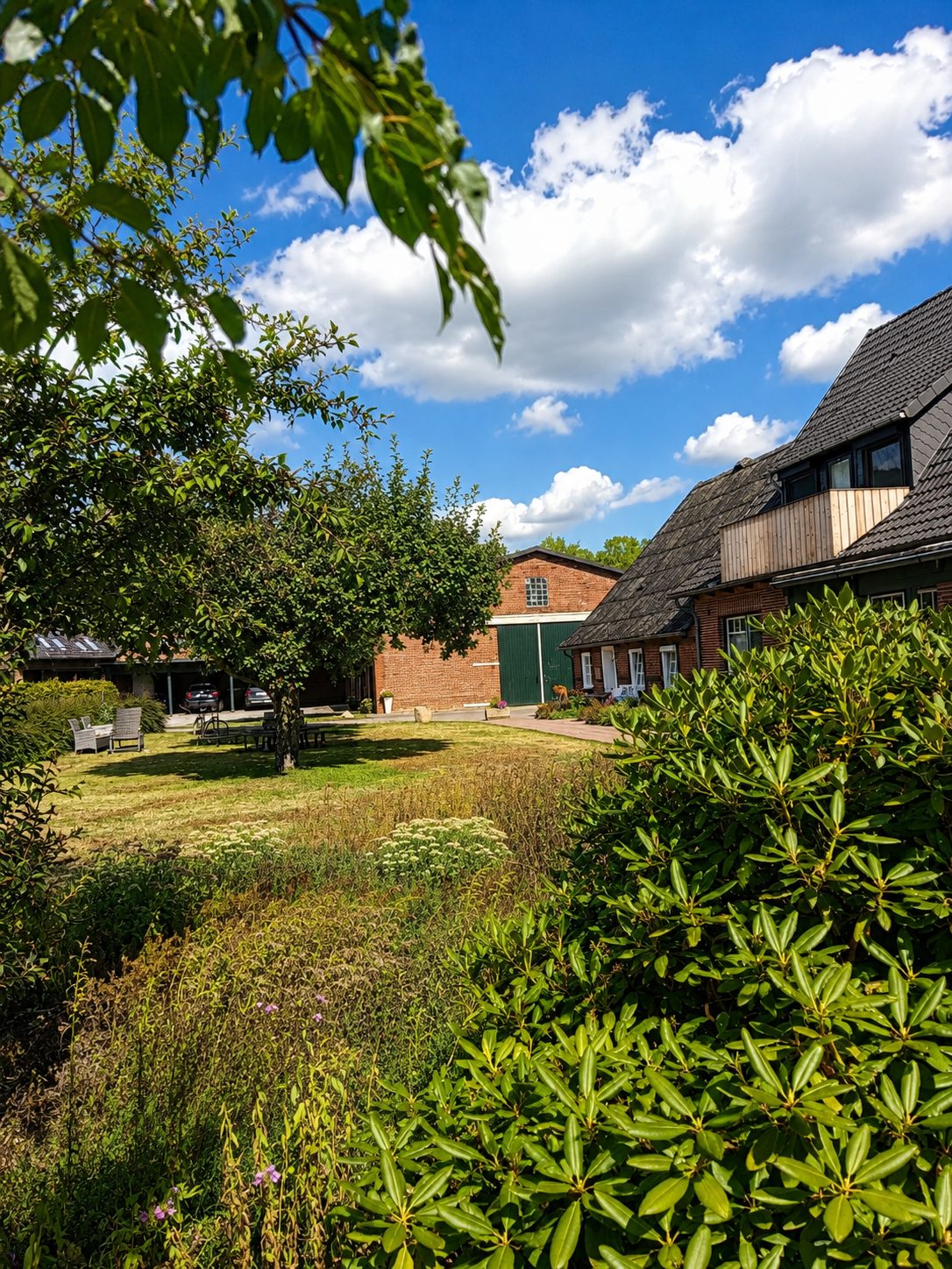 Der Resthof mit Garten unter blauem Himmel